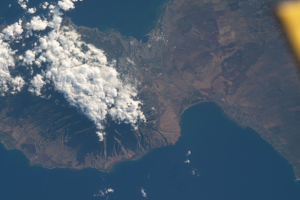 The island of Maui, Hawaii, the scene of deadly wildfires and the especially hard hit coastal town of Lahaina (at lower left), is pictured from the International Space Station as it orbited 259 miles above the Pacific Ocean.