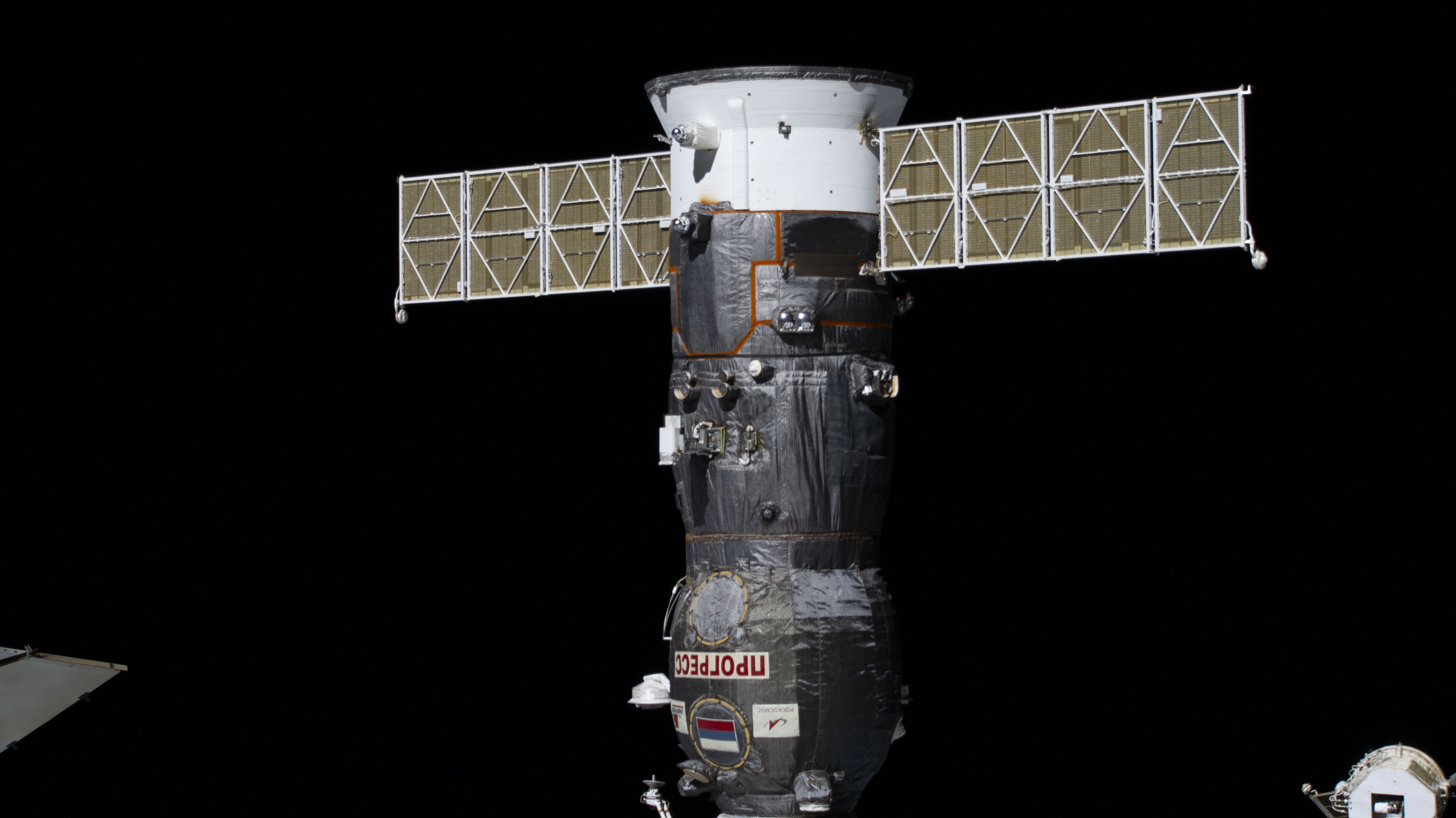 The ISS Progress 84 cargo craft is pictured docked to the Poisk module on the International Space Station.