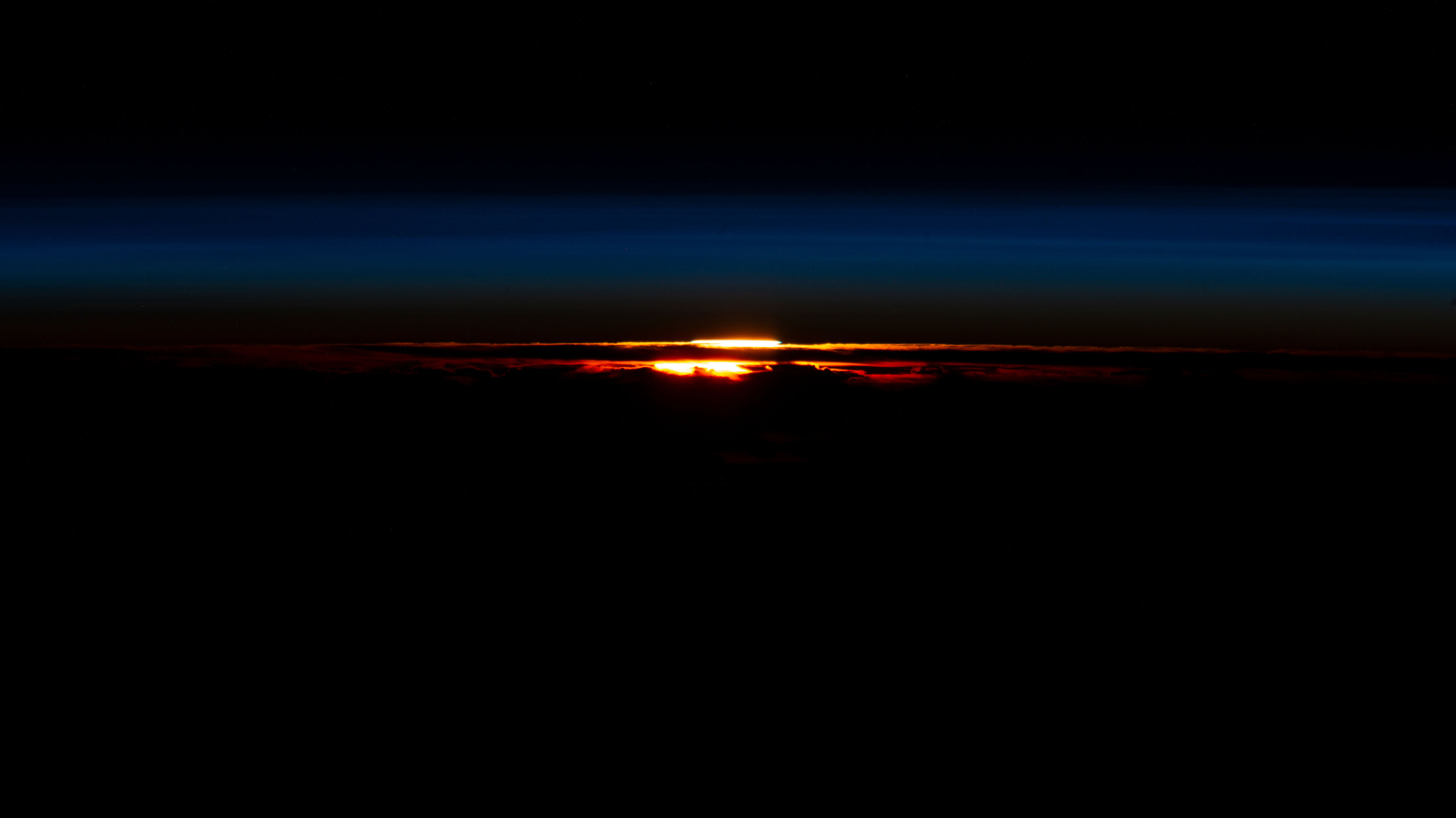 The last rays of an orbital sunset begin fading in Earth's atmosphere silhouetting the cloud tops in this photograph from the International Space Station as it orbited 271 miles above the southernmost tip of South America.