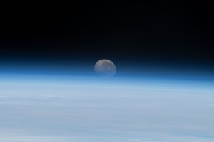 The Moon begins setting below Earth's horizon the atmosphere refracting, or bending, its light making it appear flatter in this photograph taken from the International Space Station as it orbited 262 miles above the Atlantic Ocean off the coast of Namibia.
