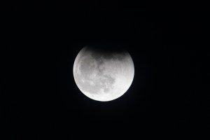 The Moon, with Earth's shadow draping across it during a lunar eclipse, is pictured from the International Space Station.