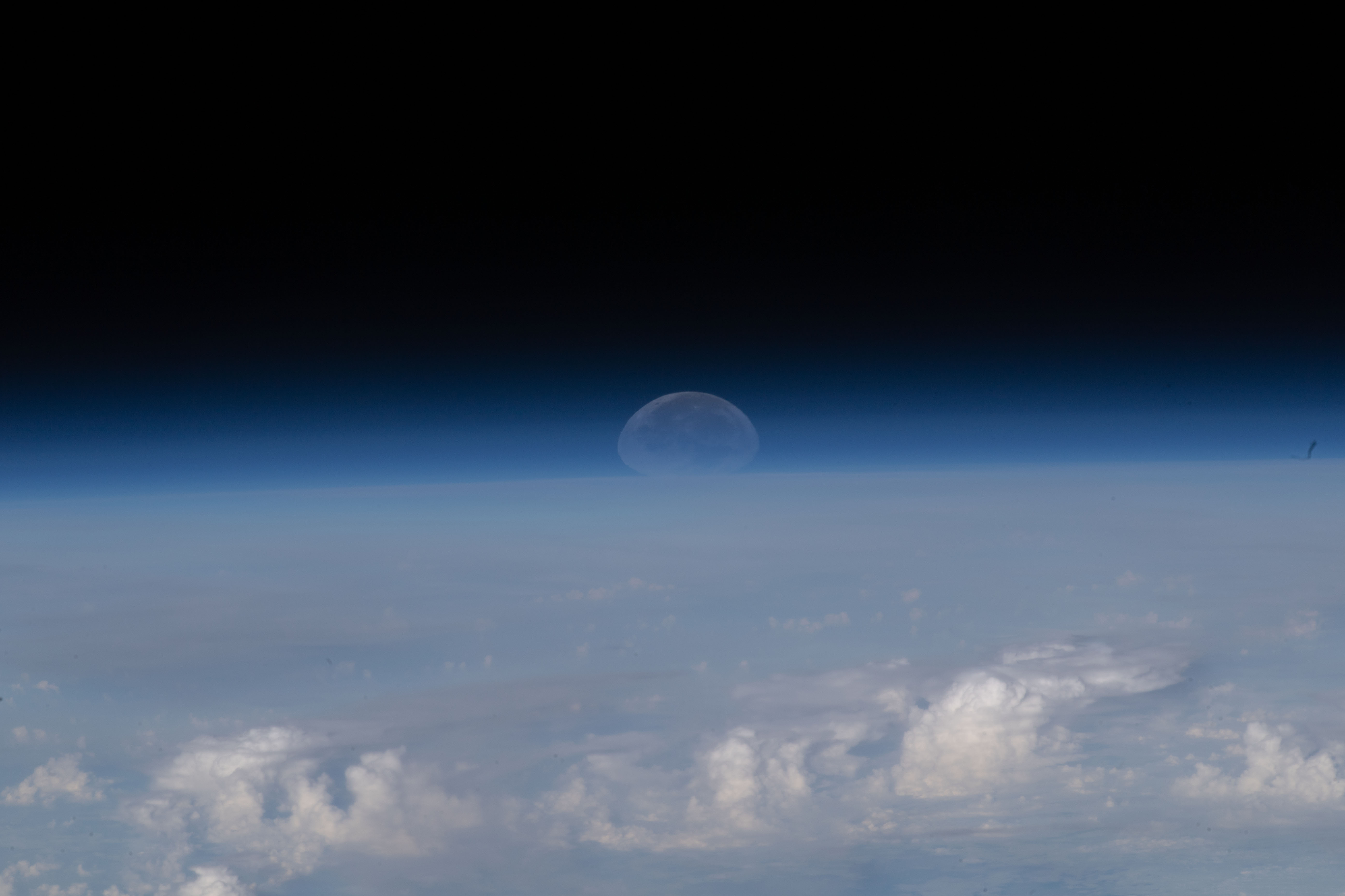 As the Moon sets below Earth's horizon the atmosphere refracts, or bends, its light making it appear flatter in this photograph taken from the International Space Station as it orbited 261 miles above the Himalayas near Kathmandu, the capital of Nepal.