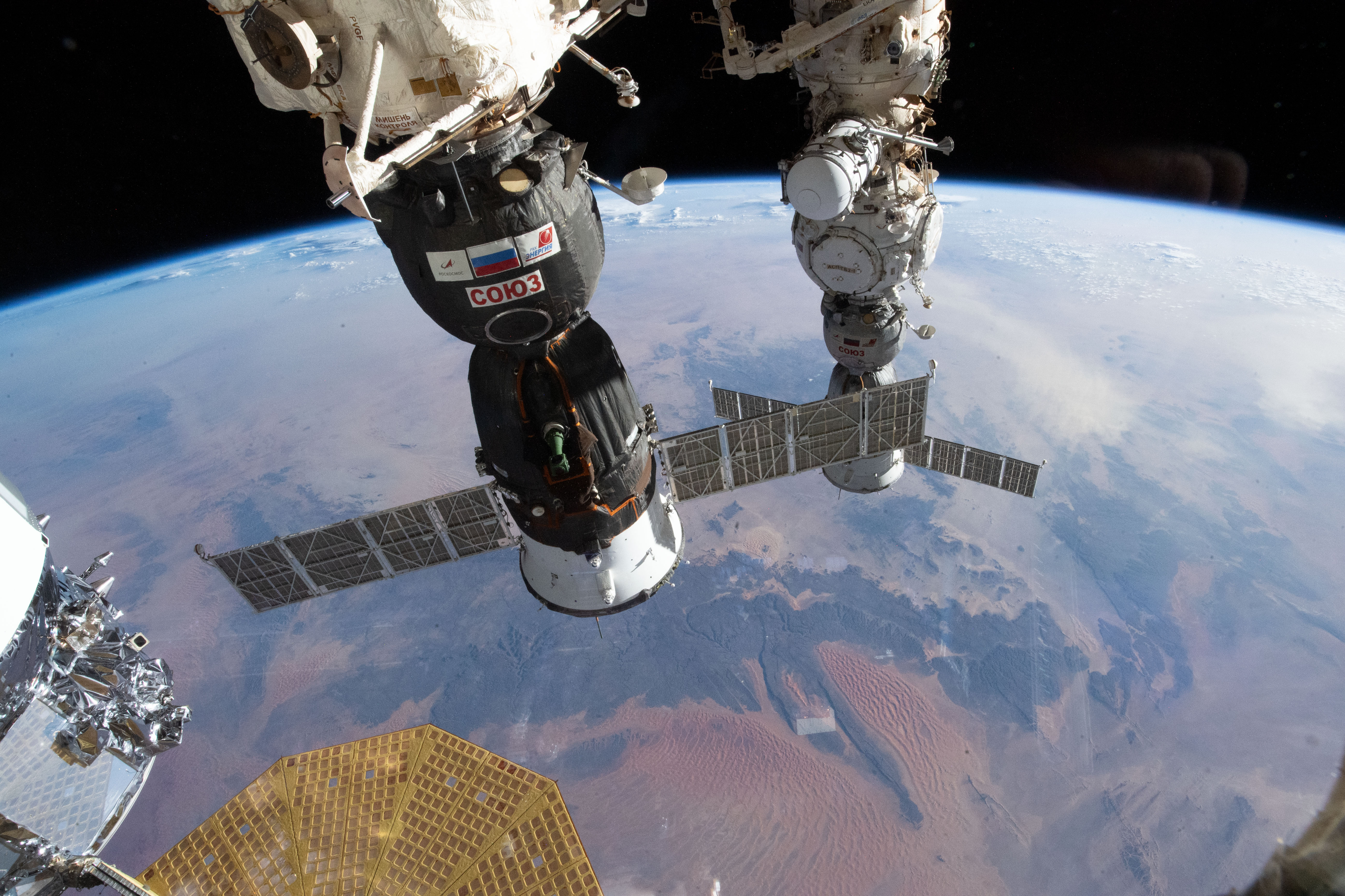 The Soyuz MS-24 spacecraft (foreground) that carried NASA astronaut Loral O'Hara and Roscosmos cosmonauts Oleg Kononenko and Nikolai Chub to the International Space Station is pictured docked to the Rassvet module. In the rear, is the Soyuz MS-23 crew ship, docked to the Prichal docking module, that will return NASA astronaut Frank Rubio and Roscosmos cosmonauts Sergey Prokopyev and Dmitri Petelin back to Earth on Sept. 27. 258 miles below the station is the Sahara desert in the African nation of Algeria.