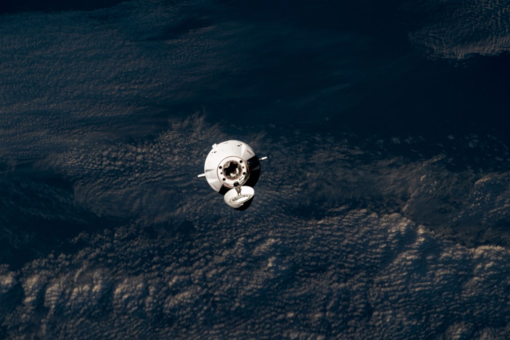 The SpaceX Dragon cargo craft approaches the International Space Station for an automated docking less than a day after launching from NASA's Kennedy Space Center loaded with over 7,000 pounds of science experiments, station hardware, and crew supplies. Both spacecraft were orbiting 259 miles above the Pacific Ocean off the coast of Japan at the time of this photograph from the orbital outpost.