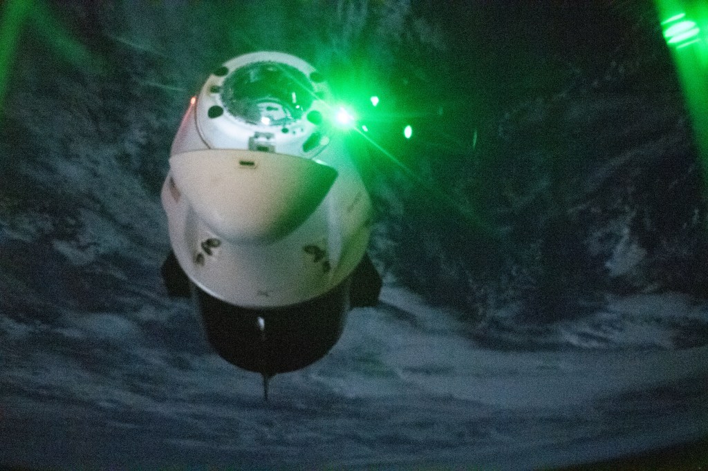 The SpaceX Dragon Endeavour spacecraft is pictured shortly after undocking from the Harmony module's space-facing port on the International Space Station during orbital night time. The red and green lights on Dragon are navigation lights with red signifying the port side of the spacecraft and green representing the starboard side.