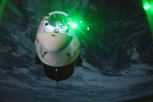 The SpaceX Dragon Endeavour spacecraft is pictured shortly after undocking from the Harmony module's space-facing port on the International Space Station during orbital night time. The red and green lights on Dragon are navigation lights with red signifying the port side of the spacecraft and green representing the starboard side.