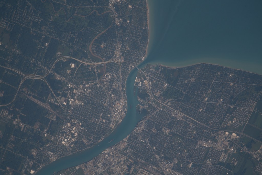 The St. Clair River separates the American city of Port Huron, Michigan (left), from the Canadian city of Sarnia, Ontario (right), and enters into Lake Huron in this photograph from the International Space Station as it orbited 263 miles above.