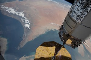 The Strait of Hormuz (bottom left) connects the Gulf of Oman with the Persian Gulf in this photograph from the International Space Station as it orbited 262 miles above southwestern Iran. In the right foreground, is the Northrop Grumman Cygnus space freighter and one of its cymbal-shaped UltraFlex solar arrays.