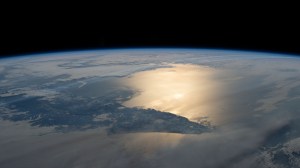 The Sun's glint breams across the Pacific Ocean and the Sea of Okhotsk, with the southern portion of the Kamchatka Peninsula in between, in this photograph from the International Space Station as it orbited 264 miles above.