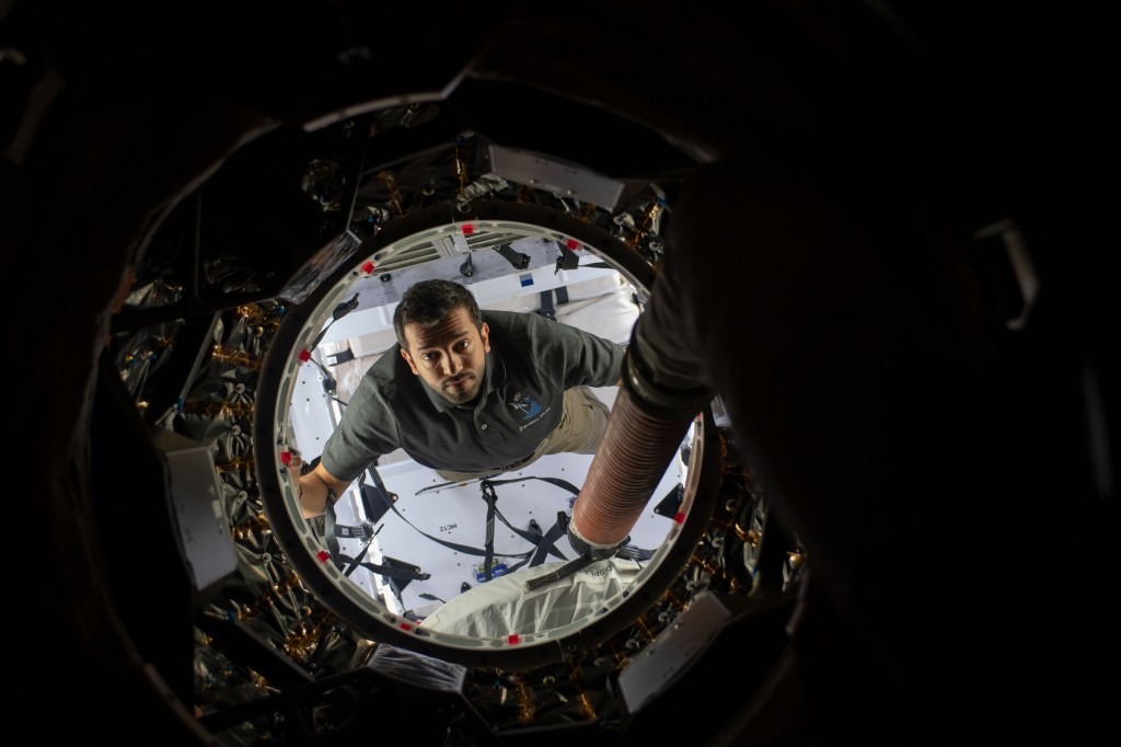 UAE (United Arab Emirates) astronaut and Expedition 69 Flight Engineer Sultan Alneyadi peers into the International Space Station while working inside the SpaceX Dragon cargo spacecraft.