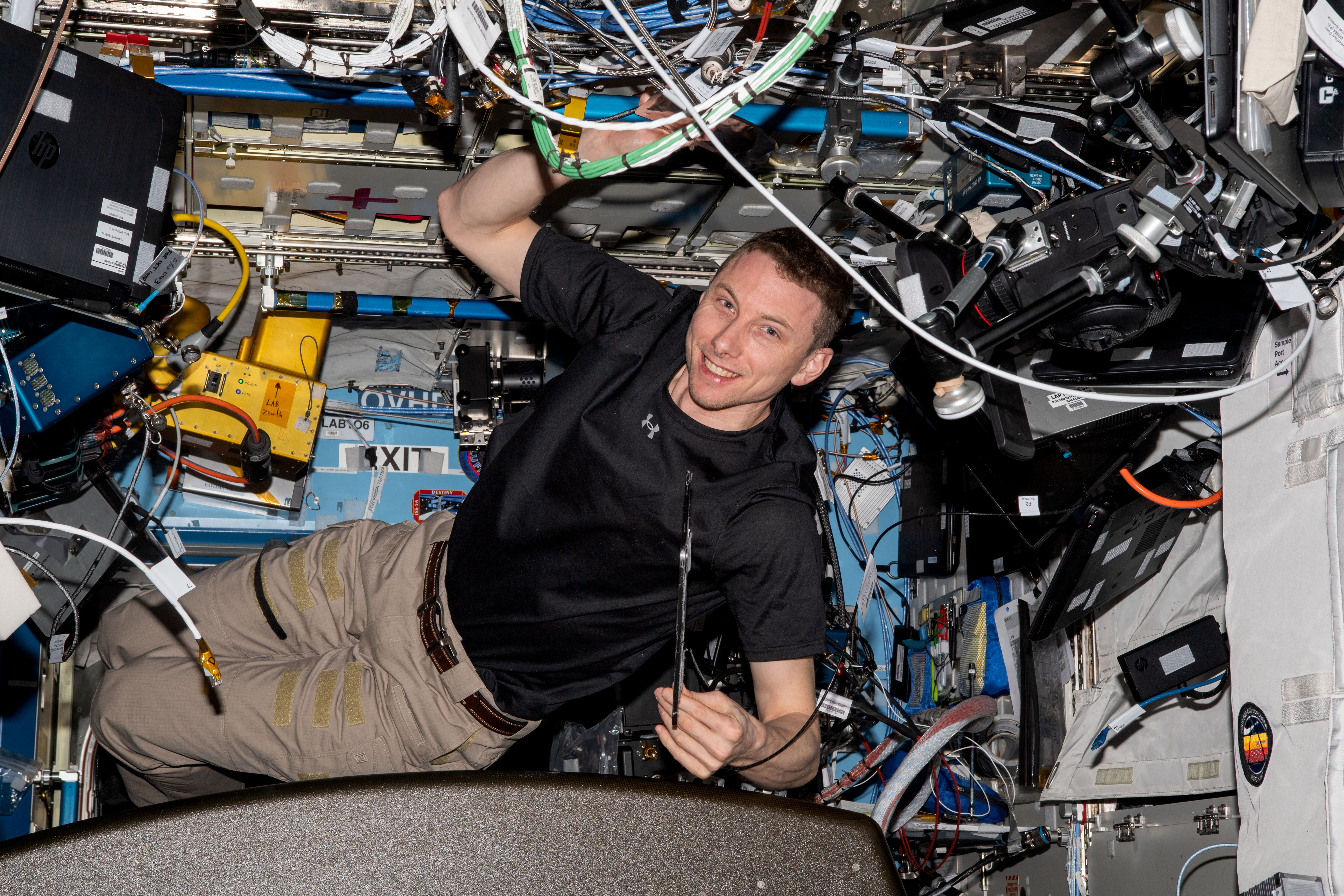 NASA astronaut and Expedition 69 Flight Engineer Woody Hoburg poses for a photo inside the Destiny module as he installs electronics and communications hardware.