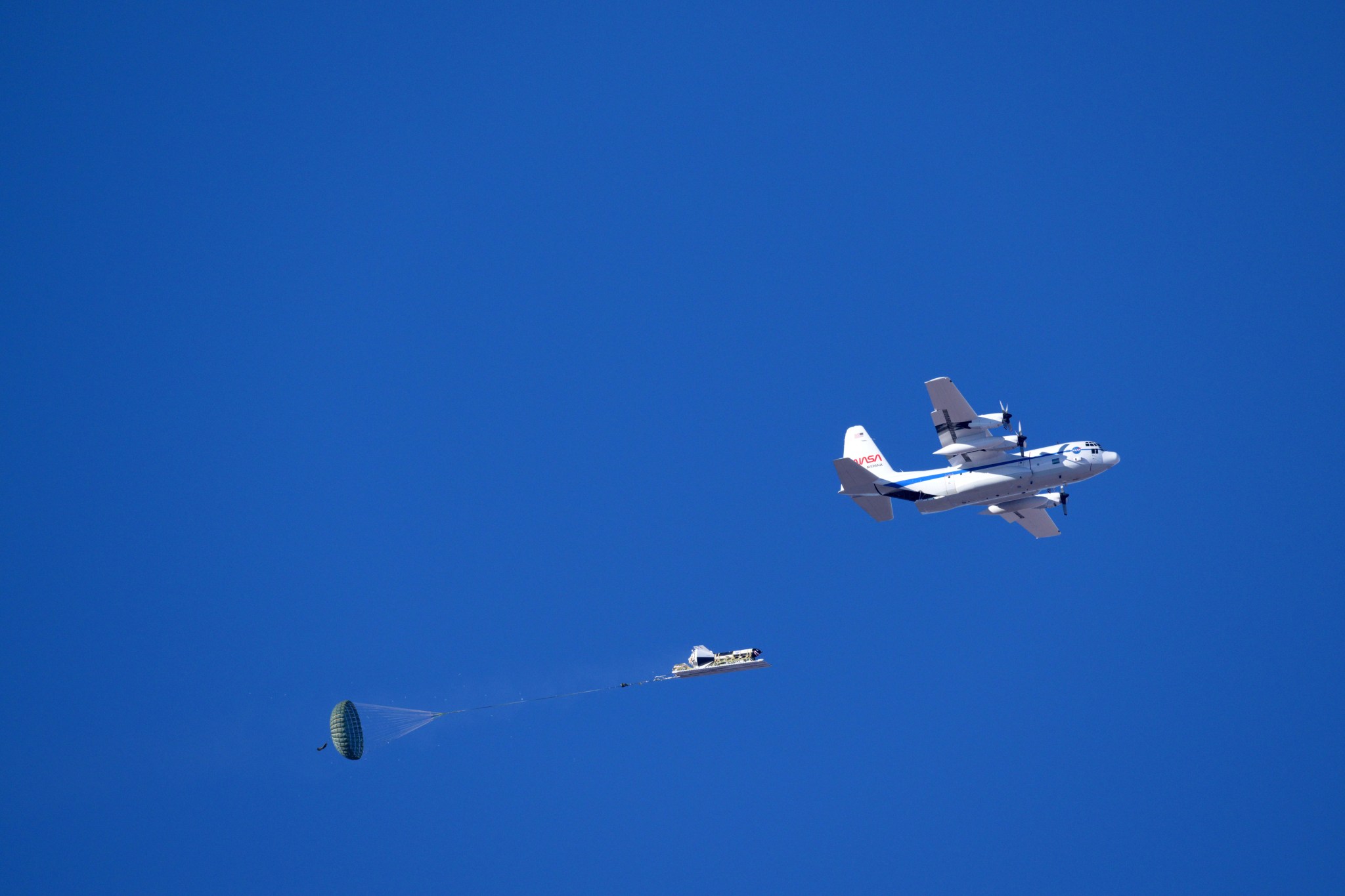 A NASA C-130 cargo aircraft releases a dart-shaped test vehicle above the U.S. Army’s Yuma Proving Ground on Jan. 9 to begin the testing sequence for a Boeing Starliner parachute system.