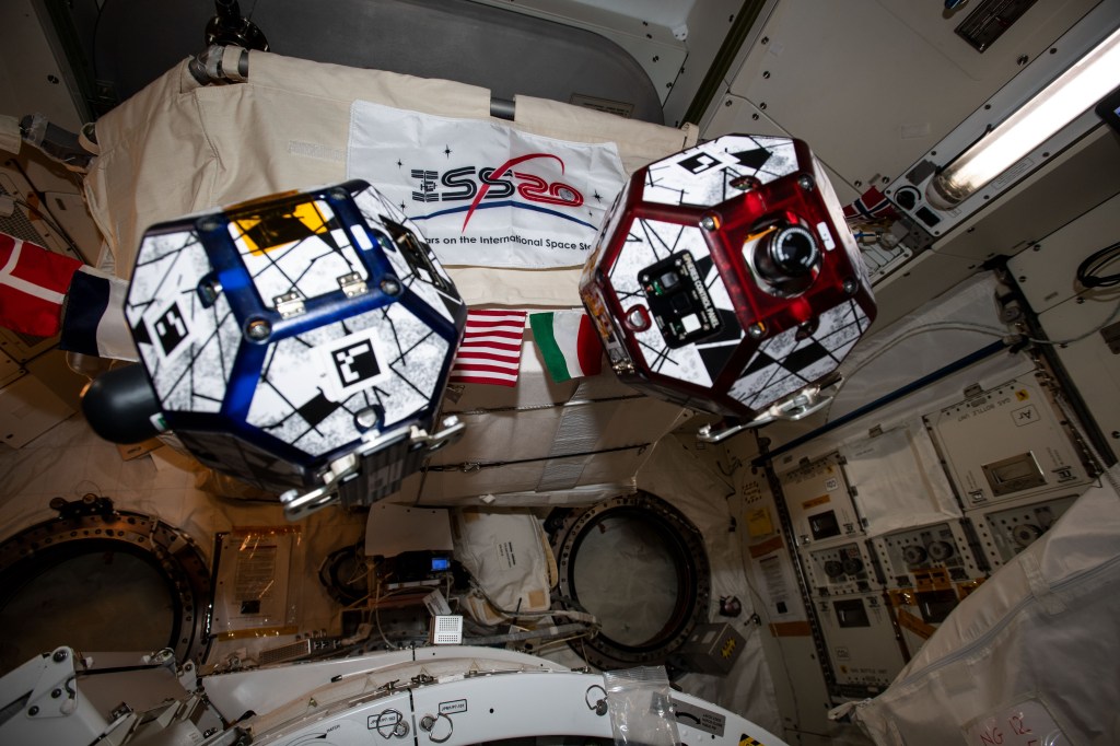 A pair of tiny, free-floating satellites, also known as SPHERES (Synchronized Position Hold, Engage, Reorient, Experimental Satellites), are pictured during a session testing formation flying using algorithms programmed in to the bowling-ball sized devices.