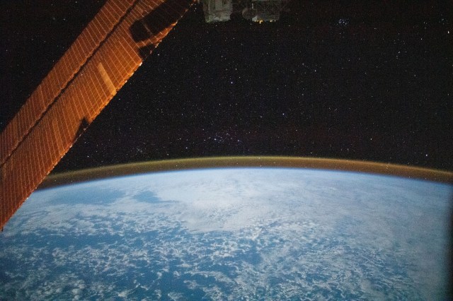 This long-exposure photograph captures a starry sky above the Earth's atmospheric glow as the International Space Station orbited above the Indian Ocean about halfway between South Africa and Australia.