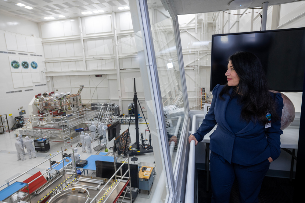 U.S. Poet Laureate Ada Limón is seen standing in NASA’s Jet Propulsion Laboratory’s High Bay 1 viewing gallery, overlooking the Europa Clipper spacecraft as it is assembled in the cleanroom.