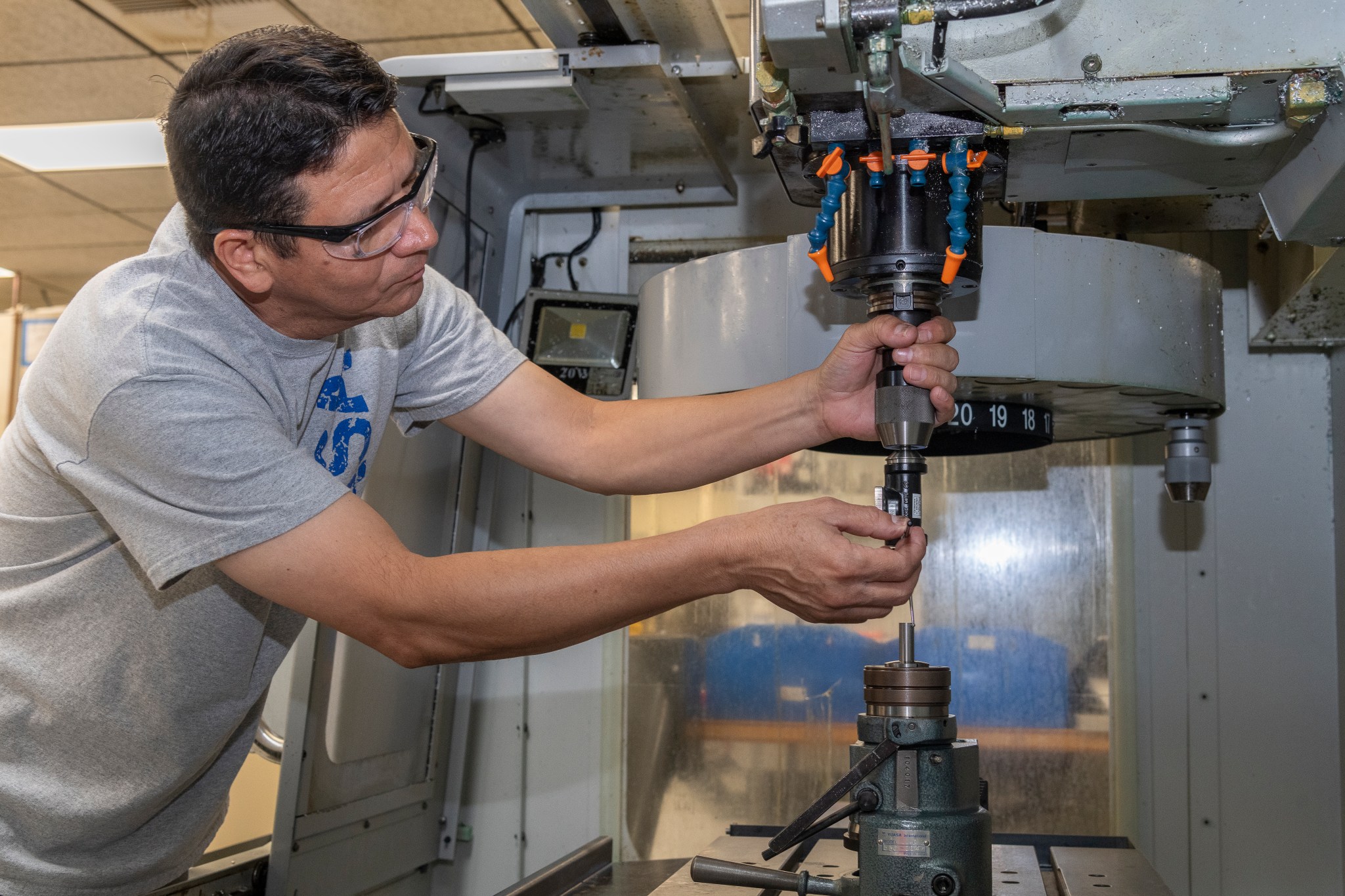 A man programs a machine to make a part for a 10-foot wing model.