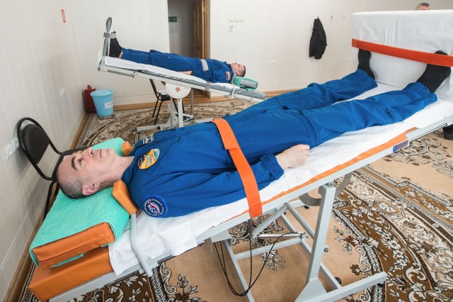 At the Cosmonaut Hotel crew quarters in Baikonur, Kazakhstan, Expedition 63 crewmembers Anatoly Ivanishin (bottom) and Ivan Vagner (top) of Roscosmos take a ride on tilt tables April 1 to test their vestibular systems. Along with Chris Cassidy of NASA, they will launch April 9 on the Soyuz MS-16 spacecraft from the Baikonur Cosmodrome in Kazakhstan for a six-and-a-half month mission on the International Space Station. Credit: Andrey Shelepin/Gagarin Cosmonaut Training Center.