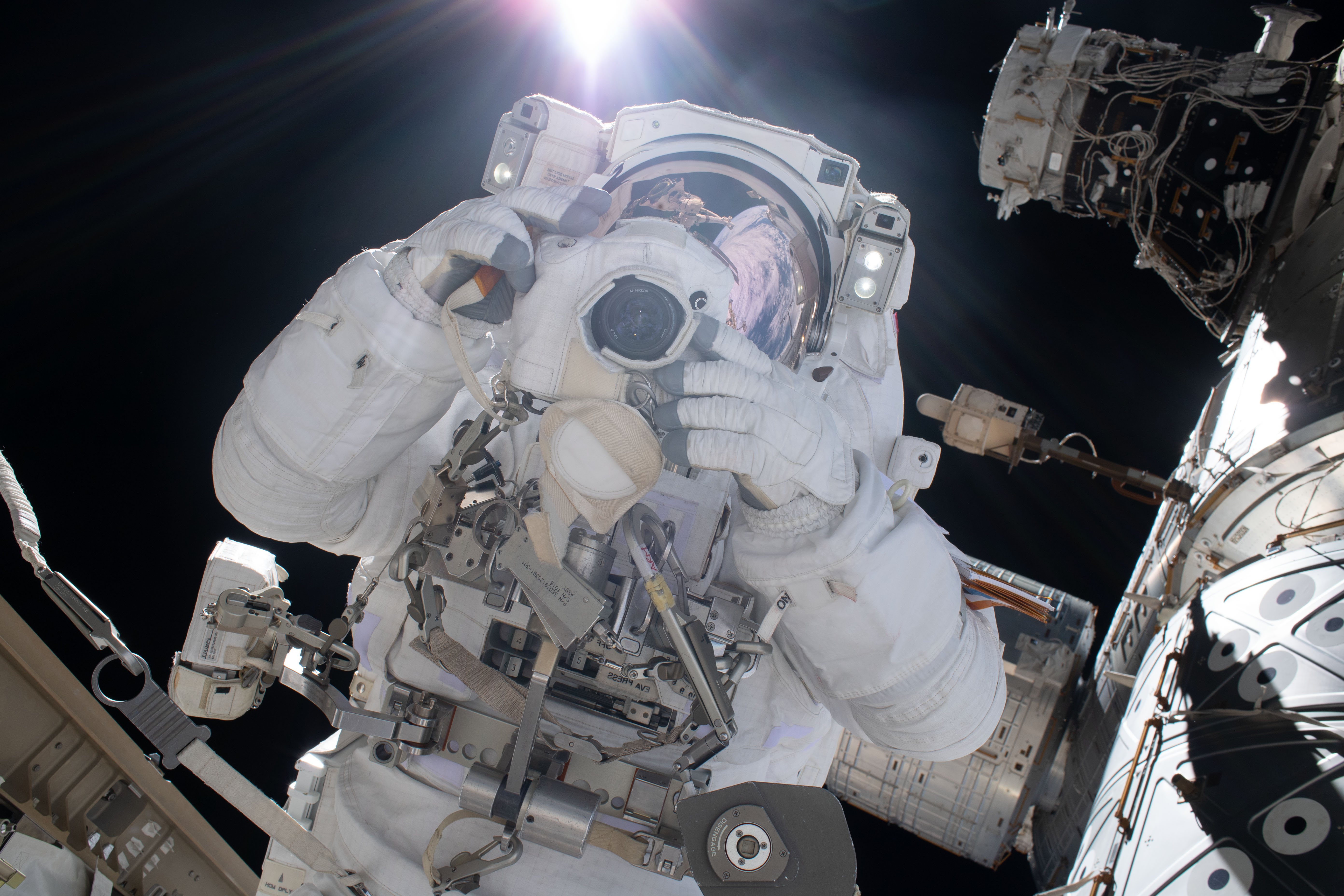 Astronaut and spacewalker Luca Parmitano of ESA (European Space Agency) takes a photograph with a camera protected from the hazards of microgravity by shielding. He and fellow astronaut Andrew Morgan (out of frame) were conducting the second spacewalk to repair the International Space Station's cosmic particle detector, the Alpha Magnetic Spectrometer.