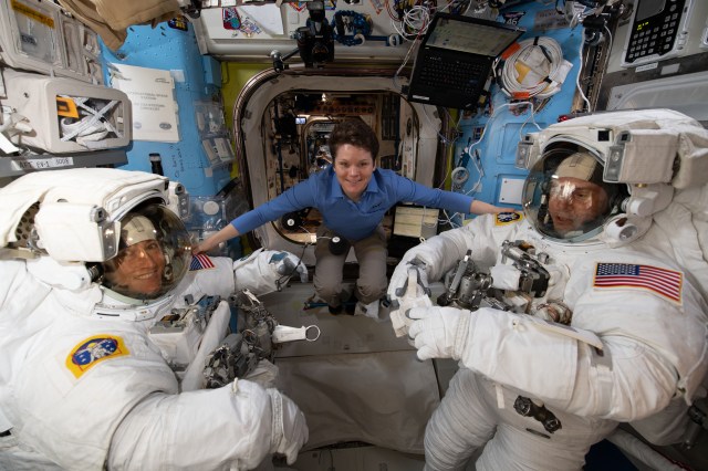 NASA astronaut Anne McClain assists fellow NASA astronauts Christina Koch (left) and Nick Hague as they verify their U.S. spacesuits are sized correctly and fit properly ahead of a set of upcoming spacewalks.