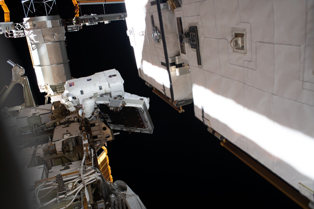 NASA astronaut Christina Koch is pictured near a solar array during a spacewalk to finalize upgrading power systems on the International Space Station's Port-6 truss structure.