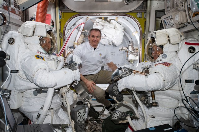 Astronaut David Saint-Jacques of the Canadian Space Agency (center) assists NASA astronauts Nick Hague (left) and Anne McClain (right) in the U.S. Quest airlock shortly before they begin the first spacewalk of their careers. Hague and McClain would work outside in the vacuum of space for six hours and 39 minutes to upgrade the International Space Station's power storage capacity.
