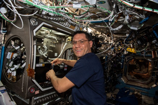iss068e045093 (Feb. 3, 2023) --- NASA astronaut and Expedition 68 Flight Engineer Frank Rubio sets up the new Particle Vibration experiment inside the Destiny laboratory module’s Microgravity Science Glovebox. The physics study will investigate how particles organize themselves in fluids possibly advancing manufacturing techniques and providing new insights on astrophysics.