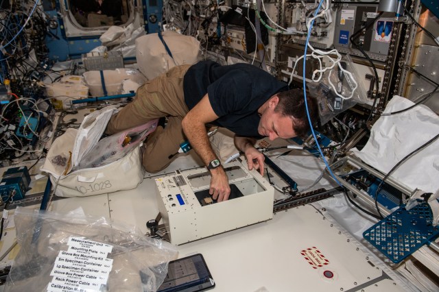 iss068e038127 (Jan. 5, 2023) --- NASA astronaut and Expedition 68 Flight Engineer Josh Cassada checks out and calibrates the mass measurement device that calculates the mass of biological research samples aboard the International Space Station.