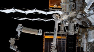iss068e026403 (Dec. 3, 2022) --- NASA astronaut and Expedition 68 Flight Engineer Josh Cassada holds a roll-out solar array as he rides the Canadarm2 robotic arm toward the Starboard-4 truss segment installation site.