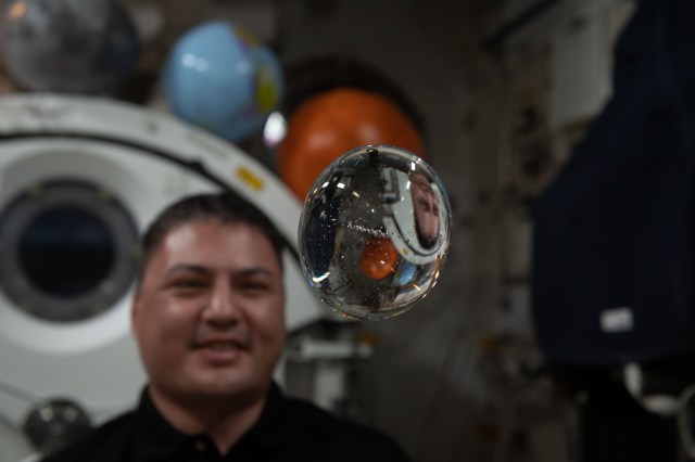 iss068e006306 (Oct. 1, 2022) --- NASA astronaut and Expedition 68 Flight Engineer Kjell Lindgren has fun with fluid physics as he observes the behavior of a free-flying water bubble inside the International Space Station's Kibo laboratory module.