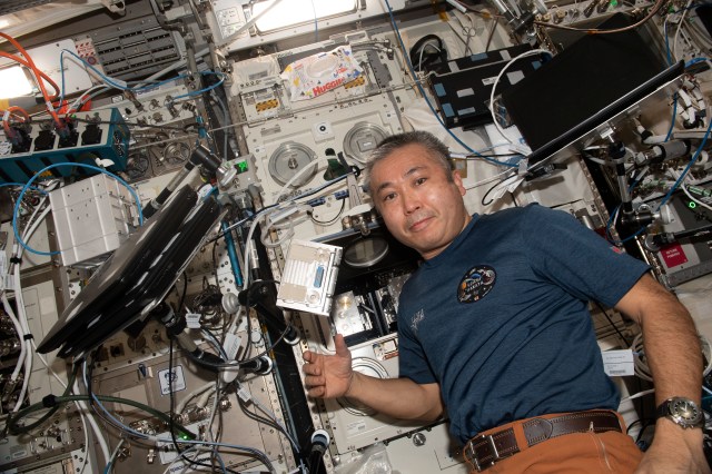 iss068e027642 (Dec. 7, 2022) --- Expedition 68 Flight Engineer Koichi Wakata of the Japan Aerospace Exploration Agency (JAXA) poses for a portrait in front of the Columbus laboratory module's BioLab, a research facility used to perform space biology experiments on microorganisms, cells, tissue cultures, small plants, and small invertebrates.