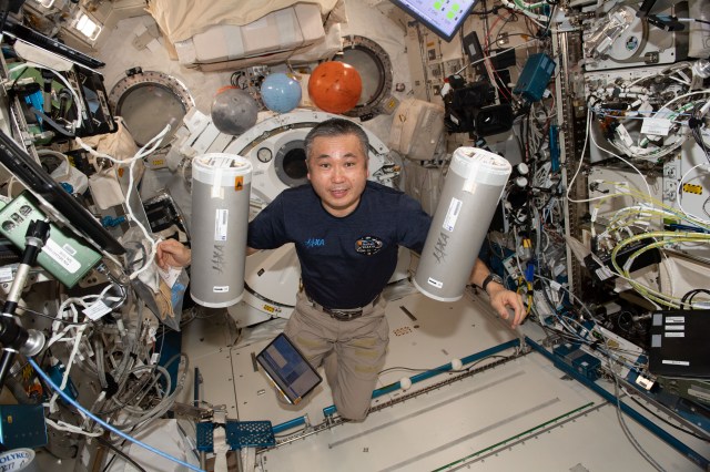 iss068e039389 (Jan. 9, 2023) --- Expedition 68 Flight Engineer Koichi Wakata of the Japan Aerospace Exploration (JAXA) retrieves research samples from science freezers inside the Kibo laboratory module in preparation for stowage inside the SpaceX Dragon cargo craft before its undocking from the International Space Station and return to Earth.