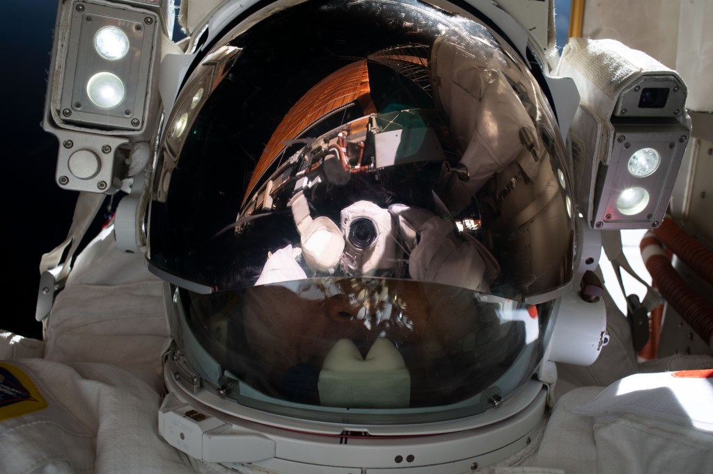 iss068e041204 (Jan. 20, 2022) --- Expedition 68 Flight Engineer Koichi Wakata of the Japan Aerospace Exploration Agency (JAXA) points the camera toward himself and takes a "space-selfie" during a seven-hour and 21-minute spacewalk to install a modification kit on the International Space Station's starboard truss structure preparing the orbital lab for its next roll-out solar array.