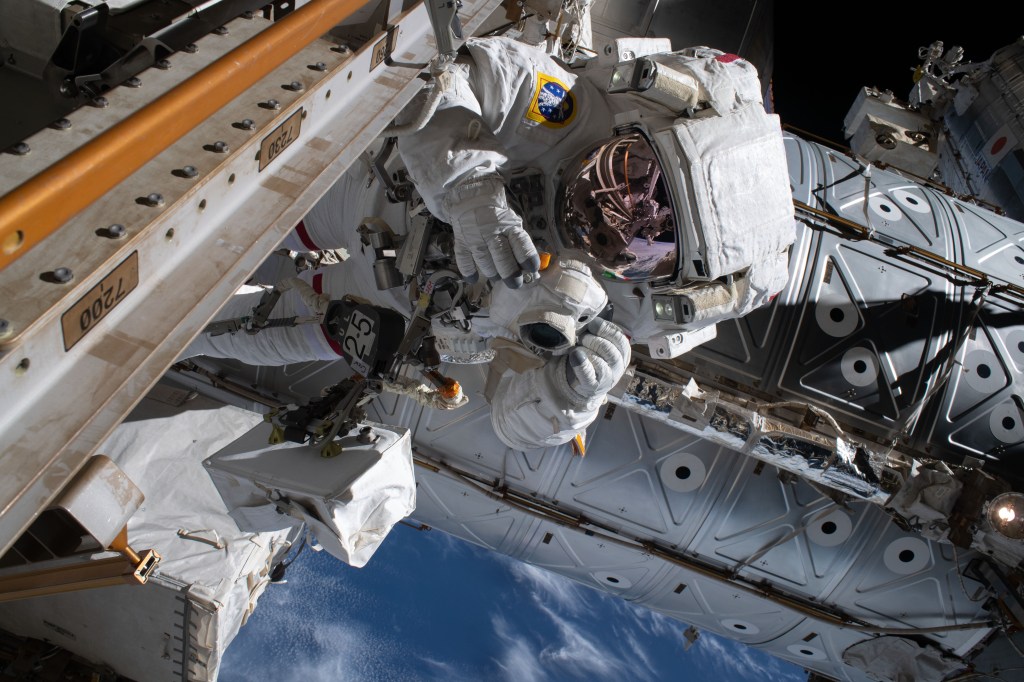 Astronaut Luca Parmitano of ESA (European Space Agency) is pictured holding a camera protected from the hazards of microgravity by shielding during the second spacewalk to repair the International Space Station's cosmic particle detector, the Alpha Magnetic Spectrometer.