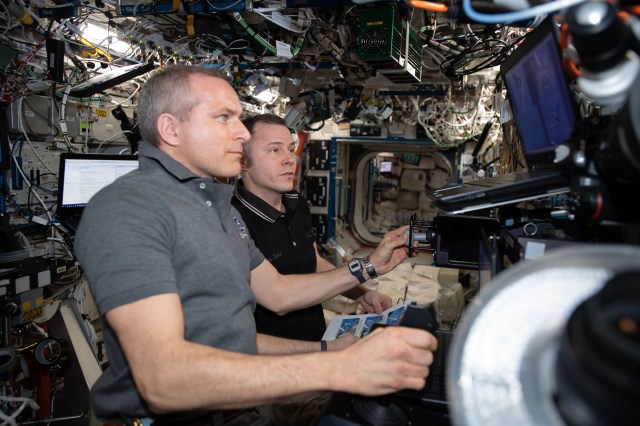 Astronauts David Saint-Jacques (foreground) and Nick Hague train to capture the SpaceX Dragon cargo craft on the robotics workstation inside the U.S. Destiny laboratory module.