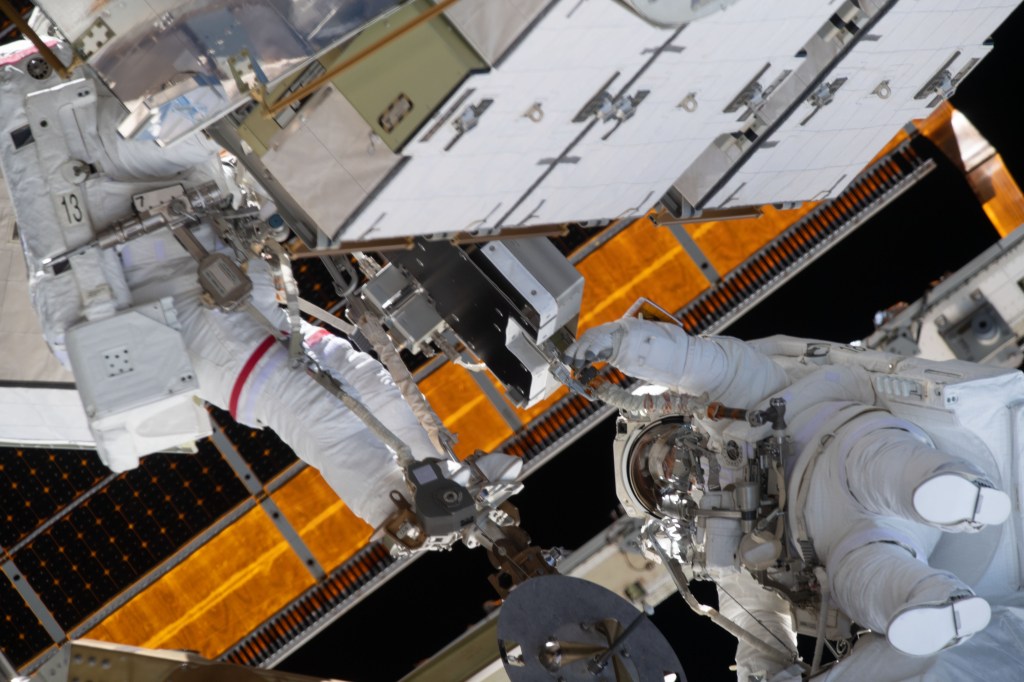 NASA astronauts Jessica Meir (left) and Christina Koch are pictured during a spacewalk to finalize upgrading power systems on the International Space Station's Port-6 truss structure.