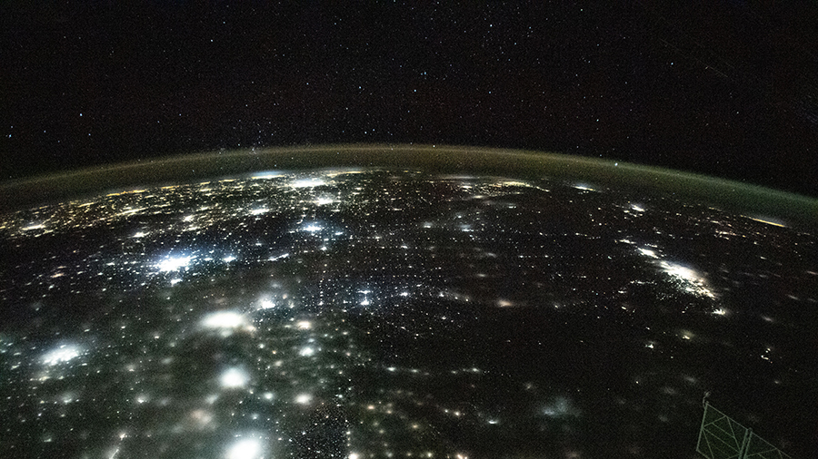 The city lights of North America appear under Earth's airglow and a starry night sky in this photograph from the International Space Station.