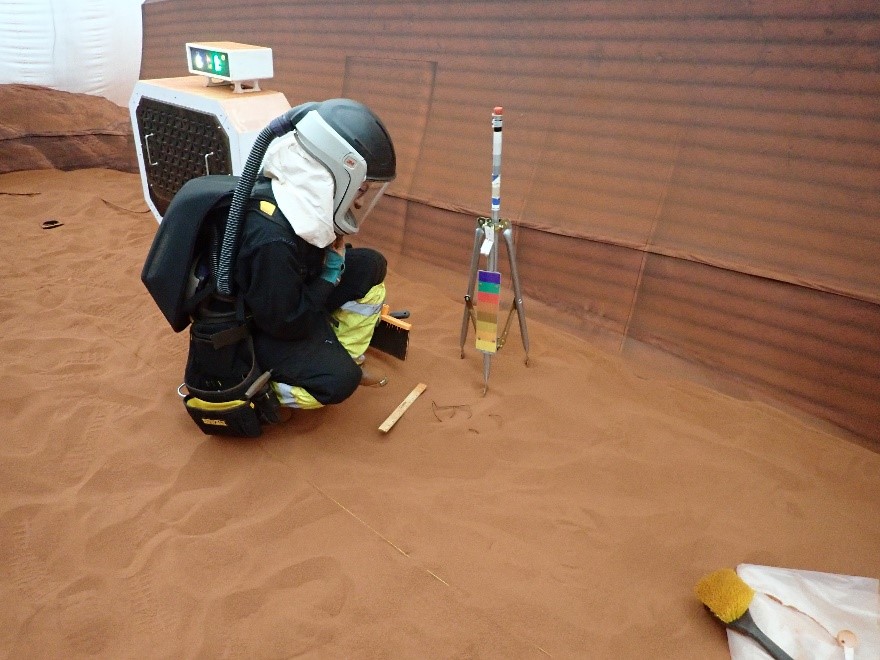 A CHAPEA crew member participates in a simulated “Marswalk” inside the 1,200-square-foot sandbox, which is filled with red sand to mimic the Martian landscape.
