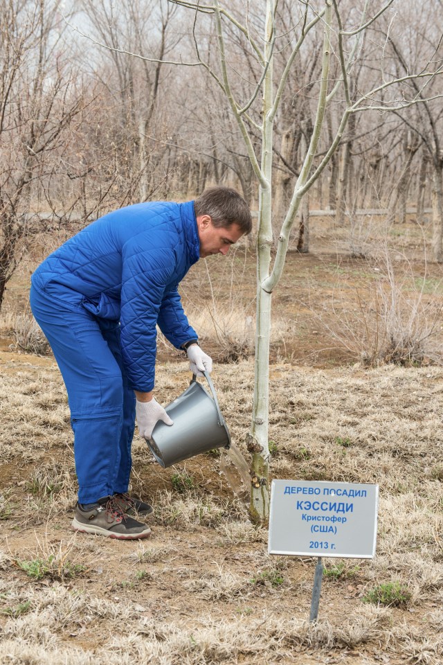 jsc2020e016974 (April 1, 2020) - At the Cosmonaut Hotel crew quarters in Baikonur, Kazakhstan, Expedition 63 crewmember Chris Cassidy of NASA waters a tree bearing his name April 1 in a traditional pre-launch activity. Cassidy and Anatoly Ivanishin and Ivan Vagner of Roscosmos will launch April 9 on the Soyuz MS-16 spacecraft from the Baikonur Cosmodrome in Kazakhstan for a six-and-a-half month mission on the International Space Station.