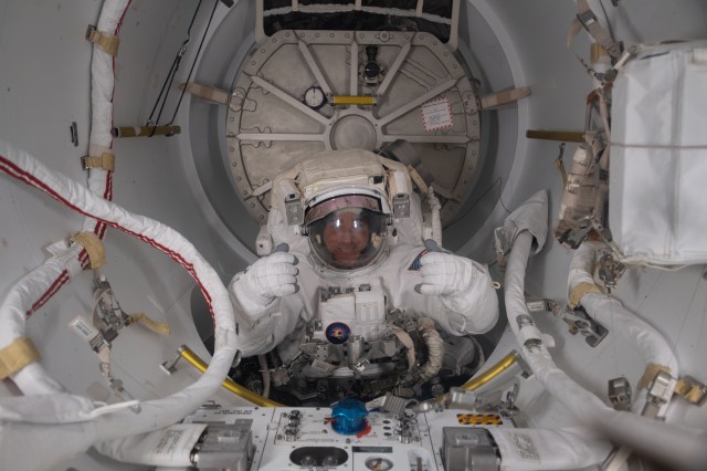 NASA astronaut and Expedition 63 Commander Chris Cassidy is pictured in his U.S. spacesuit halfway inside the crew lock portion of the Quest airlock during a spacewalk to replace batteries on the International Space Station's Starboard-6 truss structure.