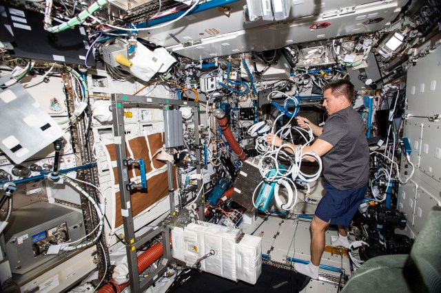 NASA astronaut and Expedition 63 Commander Chris Cassidy sets up hardware that measures pulmonary function while using the station's exercise bike, also known as the Cycle Ergometer with Vibration Isolation and Stabilization (CEVIS), located in the U.S. Destiny laboratory module.