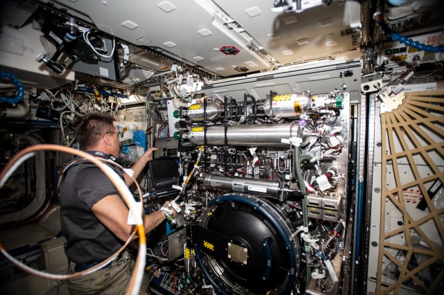 NASA astronaut and Expedition 63 Commander Chris Cassidy works on the Combustion Integrated Rack replacing components in the research device that enables safe fuel, flame and soot studies in microgravity.