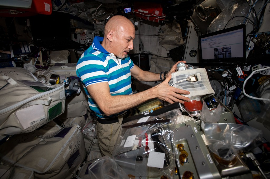 Commander Luca Parmitano of ESA (European Space Agency) installs new components in a life support system that removes carbon dioxide from the station’s atmosphere.