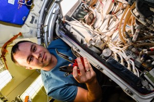 iss068e027427 (Dec. 5, 2022) --- Roscosmos cosmonaut and Expedition 68 Flight Engineer Dmitri Petelin services components inside an Orlan spacesuit aboard the International Space Station's Poisk module. Credit: Roscosmos