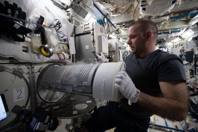 Roscosmos cosmonaut and Expedition 63 Flight Engineer Ivan Vagner transfers biological samples into a science freezer for stowage and later analysis aboard the International Space Station.