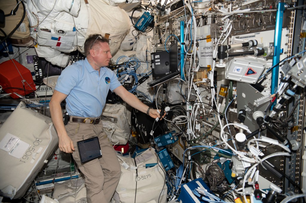 iss068e043010_alt (Jan. 28, 2023) --- Roscosmos cosmonaut and Expedition 68 Commander Sergey Prokopyev services research hardware for the Plasma Crystal experiment inside the International Space Station's Columbus laboratory module. The space physics experiment observes the behavior of clouds of highly charged particles, or plasma crystals, in a specialized chamber that may lead to improved spacecraft designs, as well as a better understanding of plasmas on Earth. Credit: Roscosmos