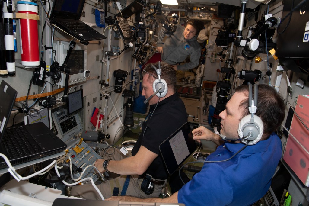 iss068e051505 (Feb. 11, 2023) --- Expedition 68 Flight Engineer Sergey Petelin (foreground) and Commander Sergey Prokopyev (middle), both Roscosmos cosmonauts, are pictured inside the Zvezda service module monitoring the automated approach and docking of the ISS Progress 83 cargo craft. Flight Engineer Anna Kikina is in the background watching the duo during the rendezvous operations.
