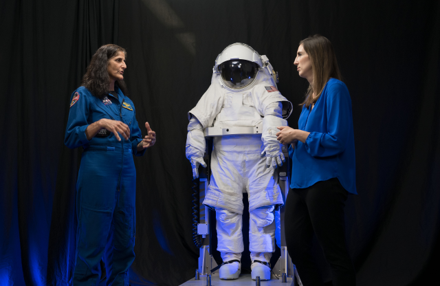 NASA astronaut Suni Williams and spacesuit engineer Carly Meginnis in front of NASA's xEMU (Exploration Extravehicular Mobility Unit) spacesuit prototype.