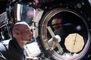 Expedition 57 Commander Alexander Gerst of ESA (European Space Agency) peers out the International Space Station's "window to the world," the seven-windowed cupola. Just outside the cupola are two spacecraft including the Soyuz MS-09 crew craft and Northrop Grumman's Cygnus cargo craft with one of its cymbal-shaped UltraFlex solar arrays featuring prominently in the frame.