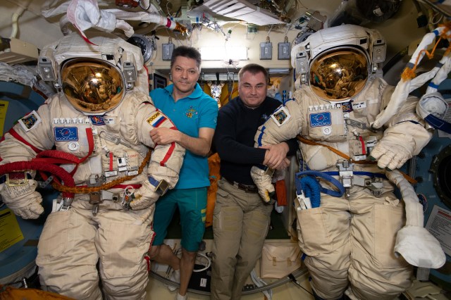 Expedition 59 Commander Oleg Kononenko (left) and Flight Engineer Alexey Ovchinin ready a pair of Russian Orlan spacesuits inside the Pirs docking compartment's airlock. Ovchinin and Kononenko are due to conduct the fourth spacewalk of 2019 for space station maintenance on May 29.