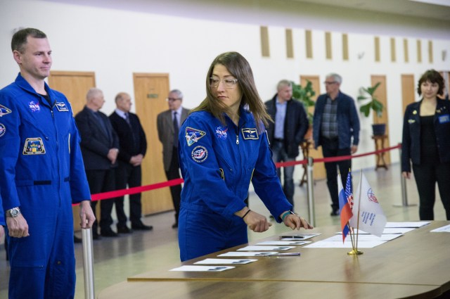 At the Gagarin Cosmonaut Training Center in Star City, Russia, Expedition 59 crew member Christina Koch of NASA prepares to sign in for the start of two days of final pre-launch qualification exams Feb. 19 as her crewmate, Nick Hague of NASA looks on. Koch, Hague and Alexey Ovchinin of Roscosmos will launch March 14, U.S. time, from the Baikonur Cosmodrome in Kazakhstan on the Soyuz MS-12 spacecraft for a six-and-a-half month mission on the International Space Station.